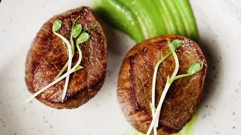 Filet mignon steak with mashed green peas and green pea sprouts, top view. Stock Footage 126222101