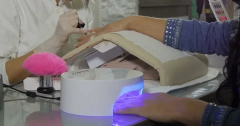 Filing and drying nails in beauty salon. Beautician working in cosmetic salon. Stock Footage 59714413