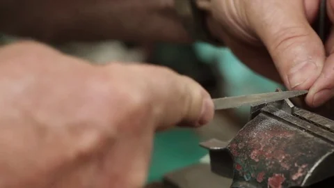 Filing Down Metal with Old Hands Stock Footage 79995511