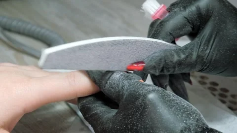 Filing the nail of the hand with a nail file. Hardware combined manicure Stock Footage 254914705