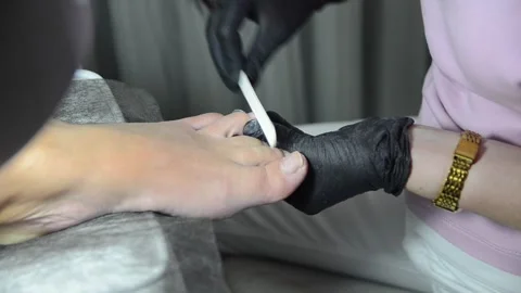 Filing toenails with nail file during professional pedicure Stock Footage 344039593