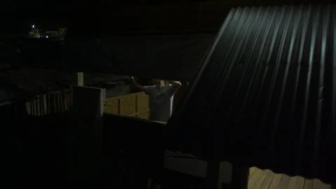 Filipino boy closing a makeshift window at night 库存影片 334371534
