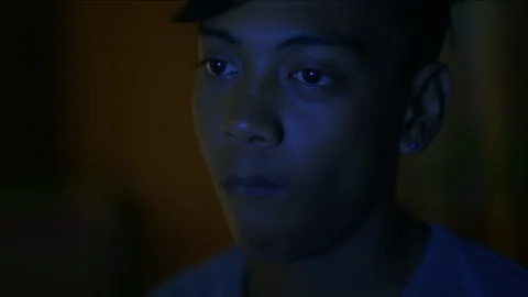 Filipino boy working on a computer at night 库存影片 334371896
