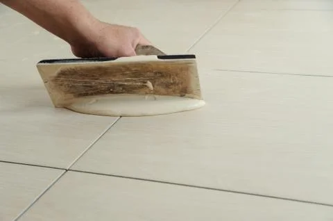 Fill the tile joints with grout Stock Photos