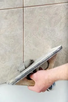 Fill the tile joints with grout. Stock Photos