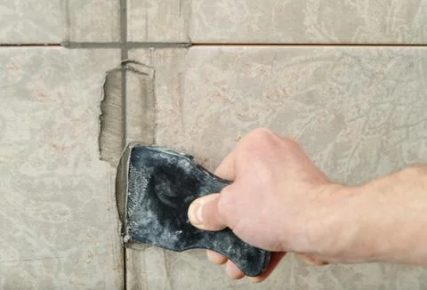 Fill the tile joints with grout. Stock Photos