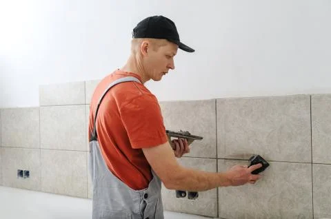 Fill the tile joints with grout. Stock Photos