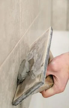 Fill the tile joints with grout. Stock Photos