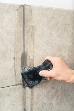 Fill the tile joints with grout. Stock Photos