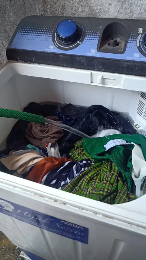 Fill the washing machine with water using a hose Stock Footage 218055241