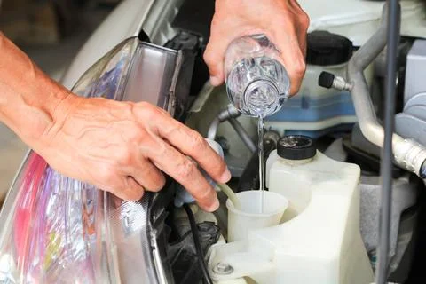 Fill the windshield water liquid on a car. Stock Photos