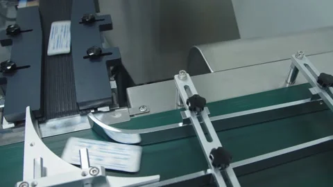 The filled and packaged medicine are moving fast on the conveyor line. Stock Footage 199686800