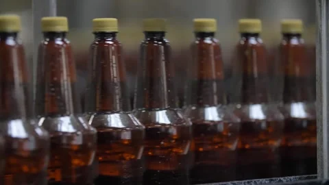 Filled bottles without labels go along the conveyor Stock Footage 240925658
