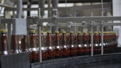Filled bottles without labels go along the conveyor Stock Footage 240925672