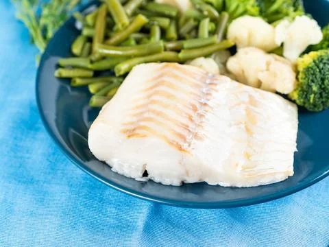 Fillet of boiled sea fish cod with broccoli, green beans and cauliflower on.. Stock Photos