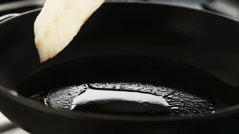 Fillet of cod gently placed in a hot cast iron pan Stock Footage 92148871