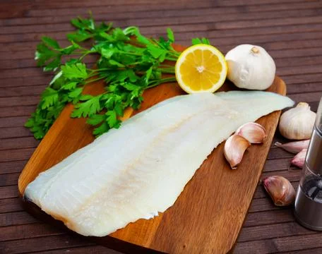 Fillet of raw cod fillet before cooking on wooden background Stock Photos