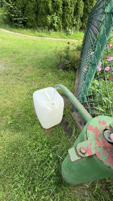 Filling 25-Liter Plastic Water Container from Outdoor Tap During Water Supp.. Stock Footage 339663047