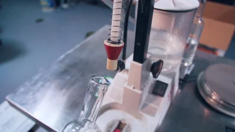 Filling of bottle of clear brandy during distillery bottling process Video stock 86711650