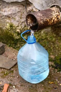 Filling  bottle by spring water Stock Photos