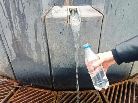 Filling a bottle with spring water Stock Photos