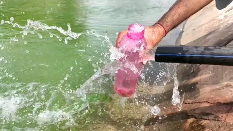 Filling the bottle with water coming from the pipe, slow motion footage Stock Footage 133617558