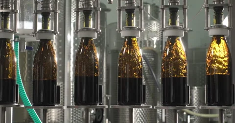 Filling bottles with red wine by the machine. Slow motion Stock Footage 249097269