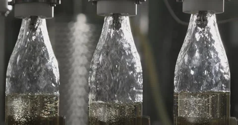 Filling bottles with white wine by the machine. Slow motion Stock Footage 249093284