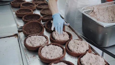 Filling Chocolate Tart Shells by Gloved Hands in Bakery. Stock Footage 321808417