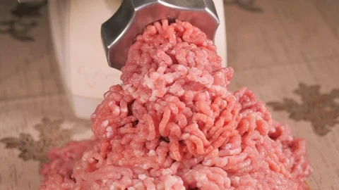 Filling comes out through a meat grinder sieve. Meat grinder close up. Pile of c Stock Footage 122589489