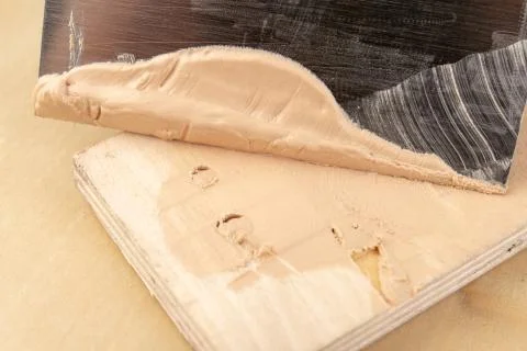 Filling compound for patching wood. Patching boards with a leveling compound. Stock Photos