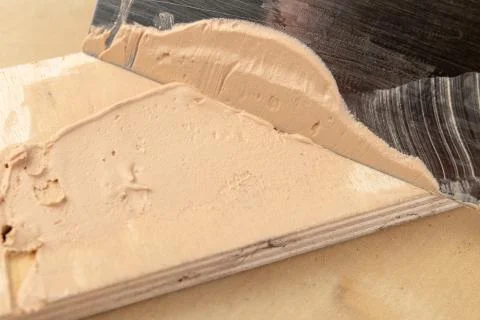 Filling compound for patching wood. Patching boards with a leveling compound. Stock Photos