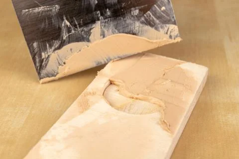 Filling compound for patching wood. Patching boards with a leveling compound. 스톡 사진