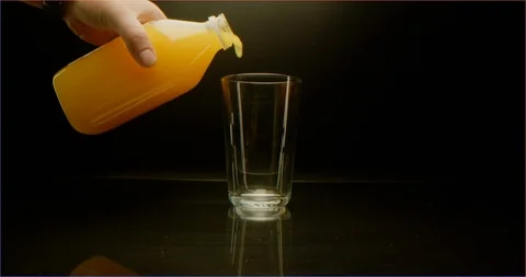 Filling up a cup with orange juice macro shot Stockbeeldmateriaal 126285630