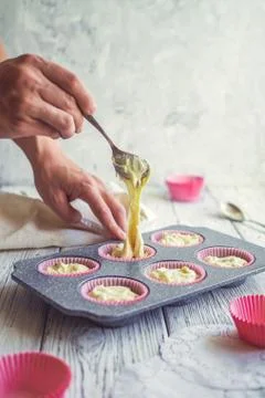 Filling a cupcake form with a test. Stock Photos