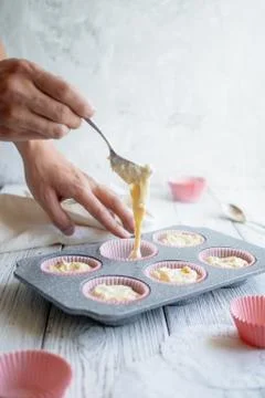 Filling a cupcake form with a test. Stock Photos