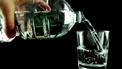 Filling a drinking glass with water with bubbles through bottle Stock-Footage 78129041