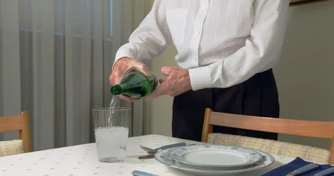 Filling empty Water Glass on dining table. Stock Footage 93690679