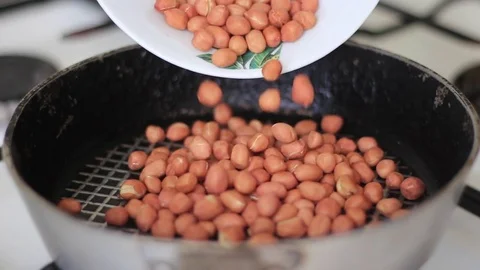 Filling a frying pan with peanuts Stockbeeldmateriaal 71982903