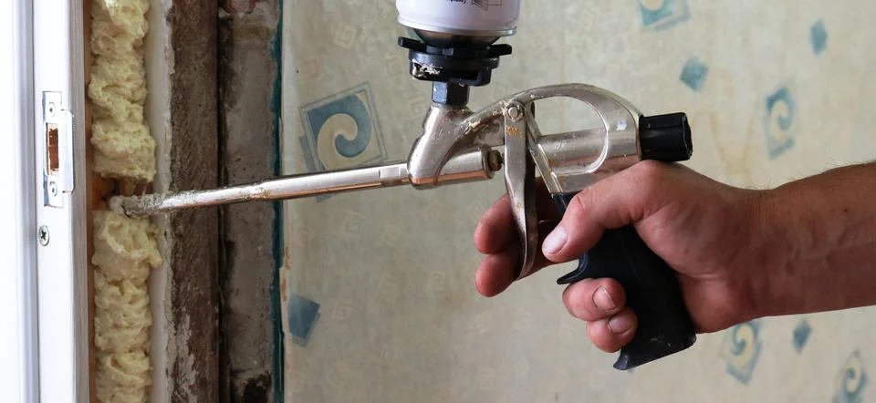 Filling the gap with polyurethane foam when fixing the door frame Stock Photos