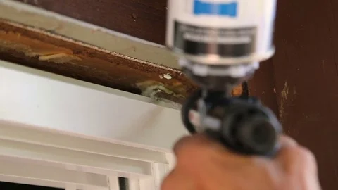 Filling gap of window with spray foam insulation Stock Footage 77277871