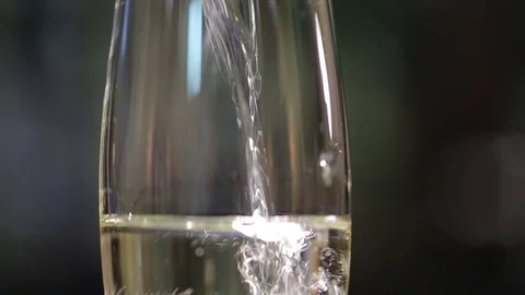 Filling up a glass with champagne close up with bubbles Stock Footage 71783933