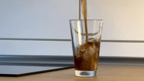 Filling a glass with cold cola or other dark colored foamy drink Stock Footage 282057382