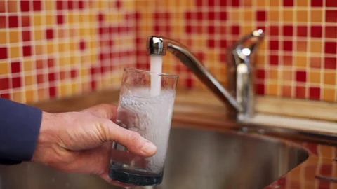 Filling up a glass with drinking water from kitchen tap Stock Footage 135512680