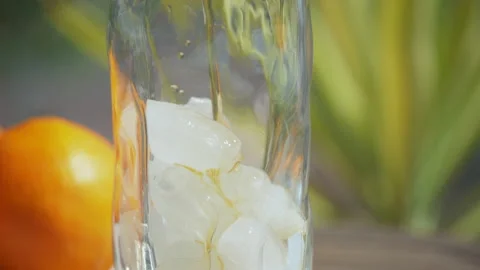 Filling a glass with ice tea, close up, outdoors Stock Footage 154336573