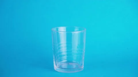 Filling a glass of milk on a blue background. Concept of filling and rich in  Stock Footage 131677398