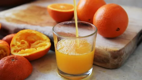 Filling a glass with orange juice. Stock Footage 178366136
