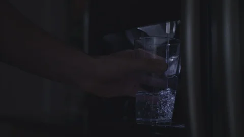 Filling a glass with water from a refrigerator. Stock Footage 86571373