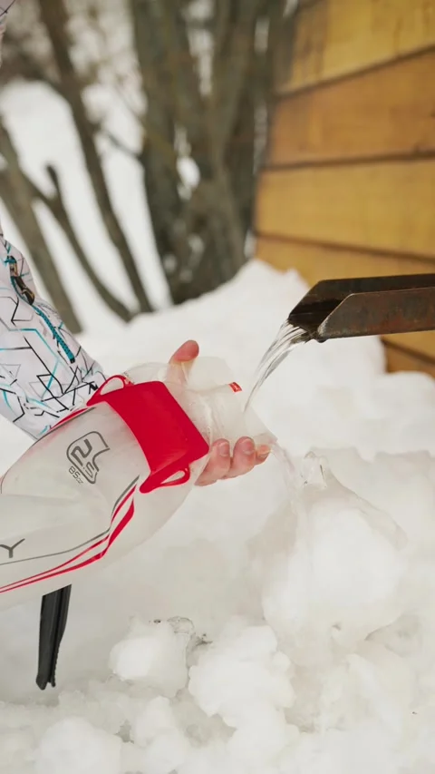 Filling a Hiking Hydration Pack with Fresh Spring Water in Winter Mountains Video stock 321669961
