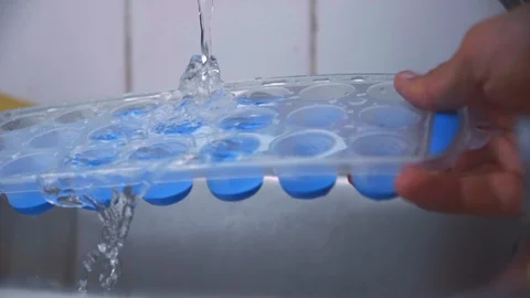Filling ice cube tray in slow motion Stock Footage 90749079